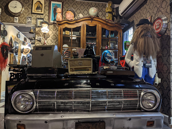 Interior de Chilean Clan con auto antiguo y decoración de época